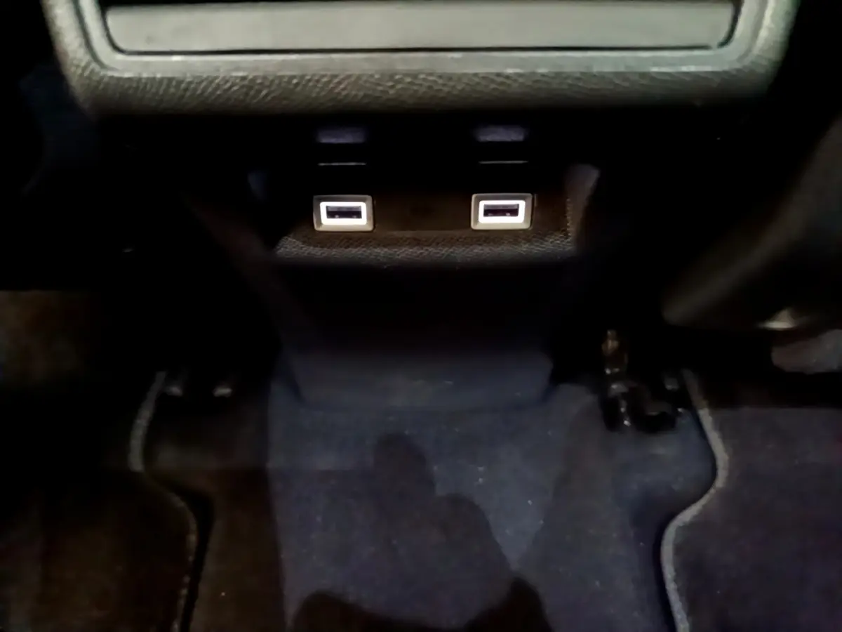 Vue intérieure rapprochée des ports USB doubles sous la console centrale du DS7 Crossback gris foncé.