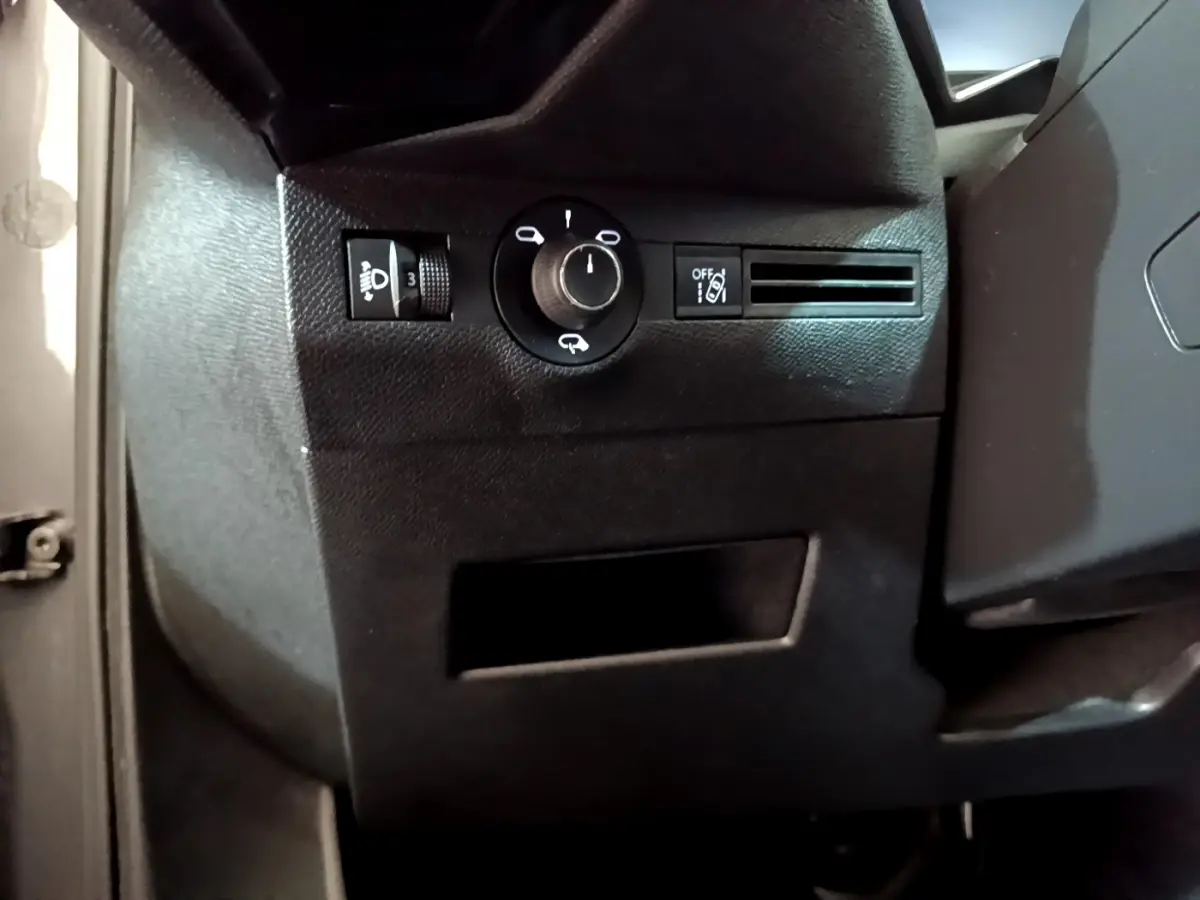 Détail intérieur du tableau de bord côté gauche du DS7 Crossback gris foncé, avec commandes d’éclairage et ventilation.