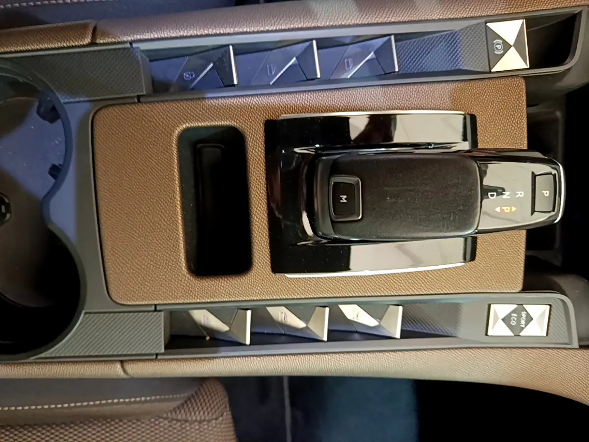 Vue rapprochée de la console centrale du DS7 Crossback 2020, avec levier de vitesses automatique et boutons de contrôle noirs et marron.