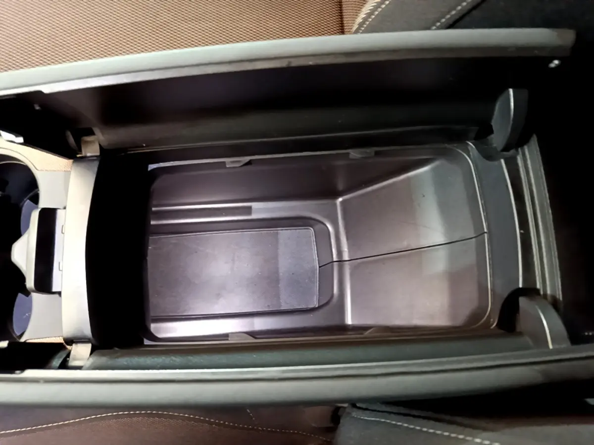 Vue plongeante sur le rangement central ouvert du DS7 Crossback Business 2020, intérieur noir et tissu marron.