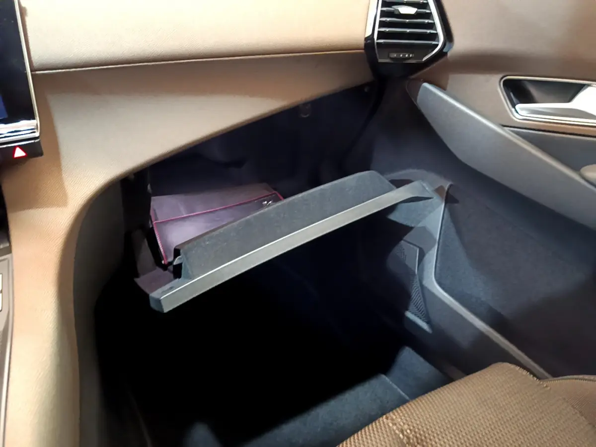 Vue intérieure côté passager du DS7 Crossback 2020, boîte à gants ouverte avec pochette noire visible.