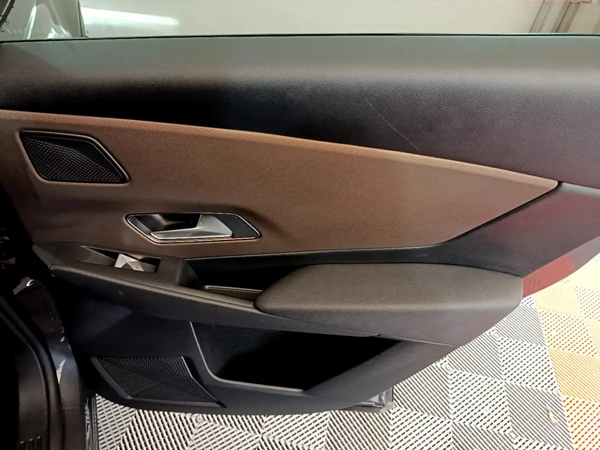 Vue rapprochée de la porte avant gauche gris foncé du DS7 Crossback 2020 avec habillage tissu et commandes intégrées.