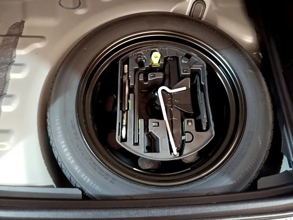Vue en plongée sur la roue de secours et ses outils dans le coffre du DS7 Crossback gris foncé de 2020.