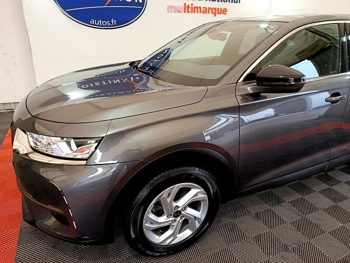 Vue 3/4 avant droit d’un DS7 Crossback gris foncé avec jantes alliage et rétroviseur noir brillant.