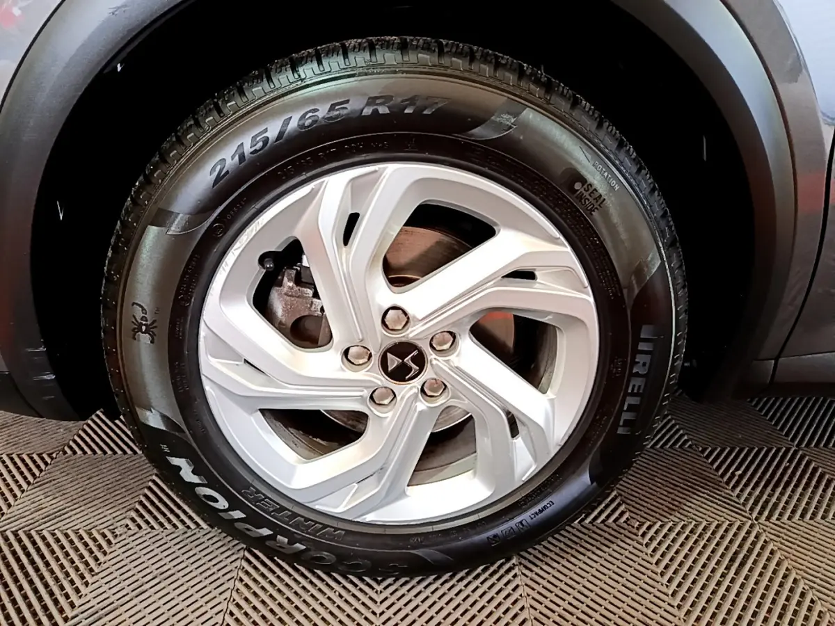 Gros plan sur la roue avant droite du DS7 Crossback gris foncé avec jante alliage et pneu Pirelli Scorpion.