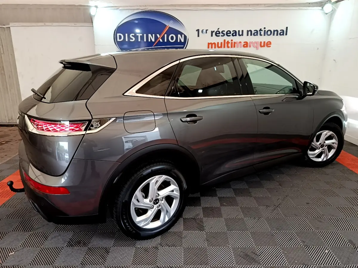 Vue 3/4 arrière droite du DS7 Crossback gris foncé avec feux arrière LED et jantes alliage cinq branches.