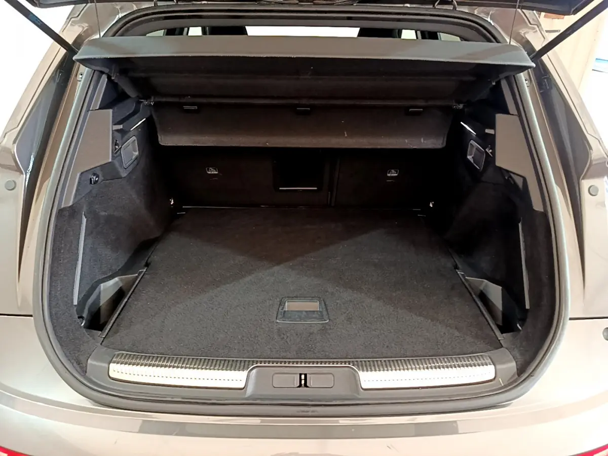 Vue arrière du coffre ouvert du DS7 Crossback gris foncé, montrant un espace de chargement spacieux et bien fini.