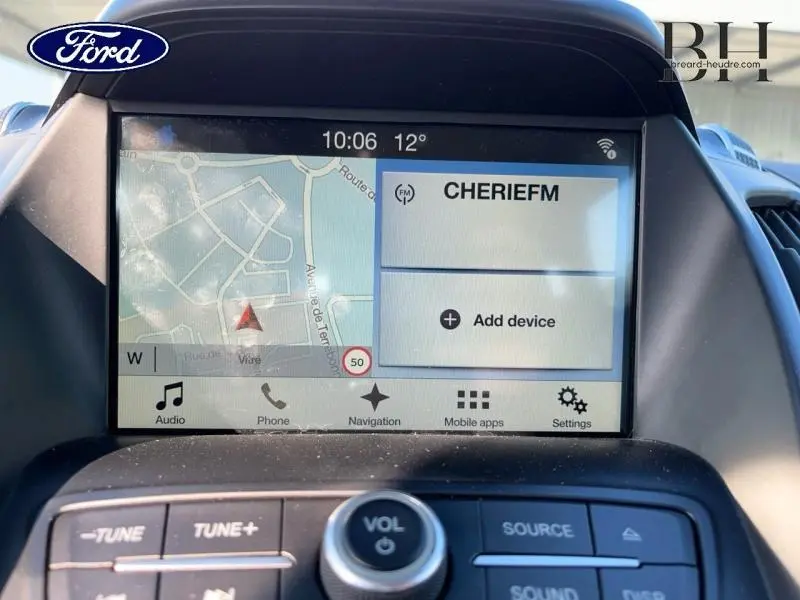 Écran tactile central du Ford Kuga blanc Glacier 2018 affichant la navigation et la radio en intérieur.