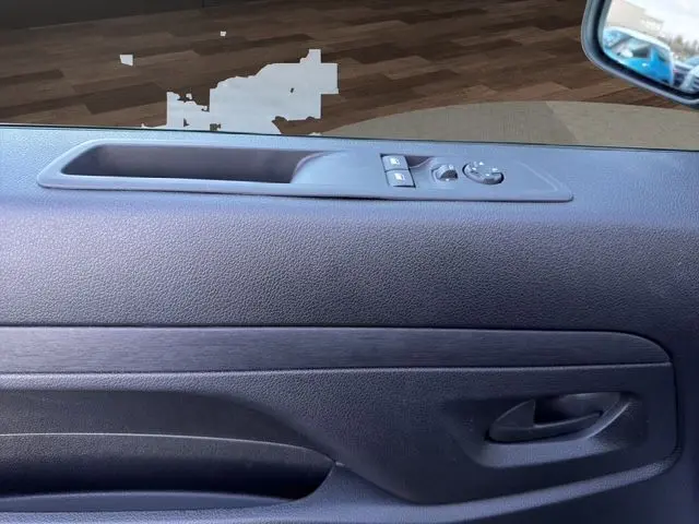 Vue rapprochée de la porte intérieure côté gauche du Citroën Jumpy noir, avec commandes de vitres et rétroviseur.