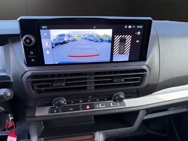 Vue rapprochée de l'écran central du tableau de bord du Citroën Jumpy noir, affichant la caméra de recul et les commandes climatiques.