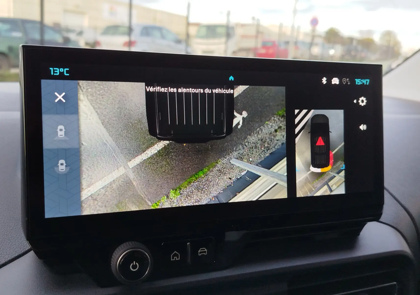 Écran intérieur du Citroën Berlingo Kaolin White 2025 montrant la caméra de recul avec vue aérienne du véhicule en stationnement.