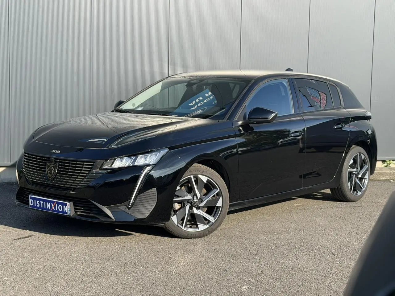 Peugeot 308 noir Perla vue 3/4 avant droit, avec jantes alliage 17'' et signature lumineuse LED distinctive.