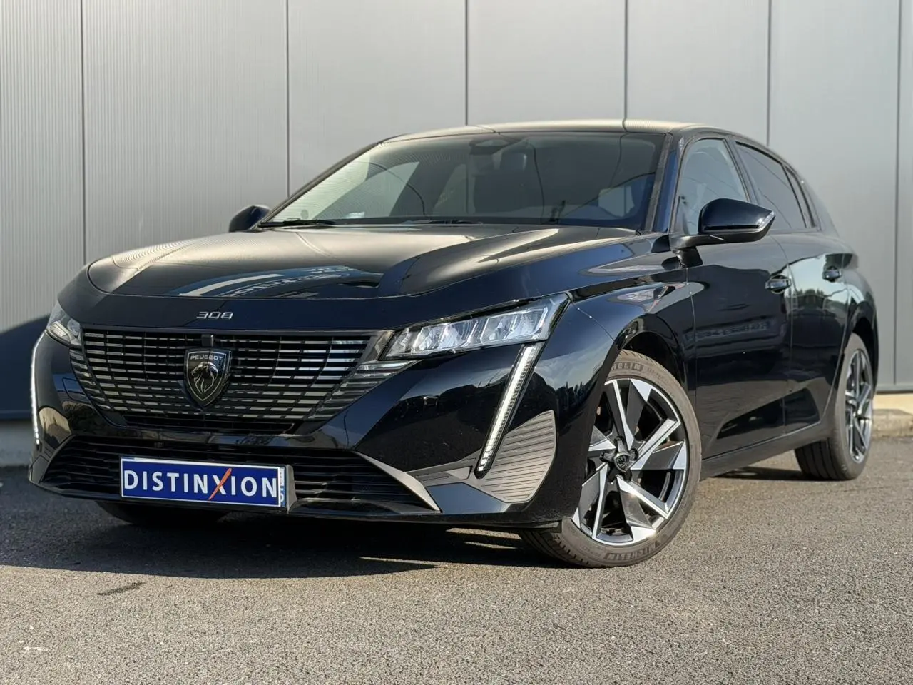 Peugeot 308 noir Perla vue 3/4 avant droit, avec calandre distinctive et feux LED verticaux marquants.