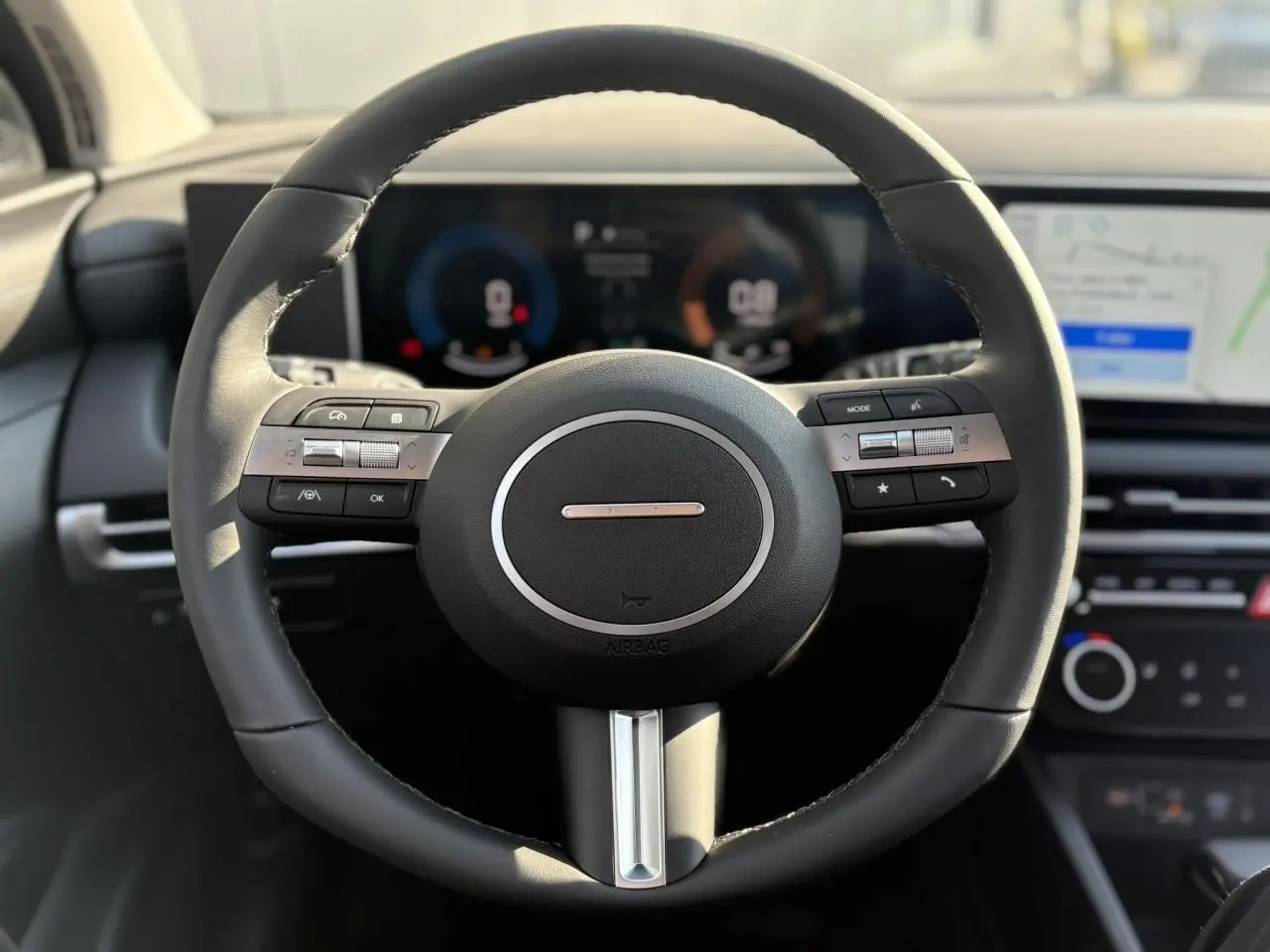 Volant cuir noir vu de face dans l'habitacle du Hyundai Tucson 2025 avec tableau de bord numérique et écran tactile.