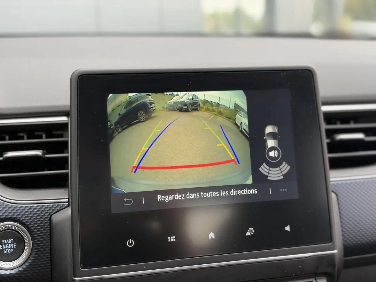 Écran tactile intérieur montrant la caméra de recul avec lignes de guidage sur un Renault Arkana noir métal 2024.