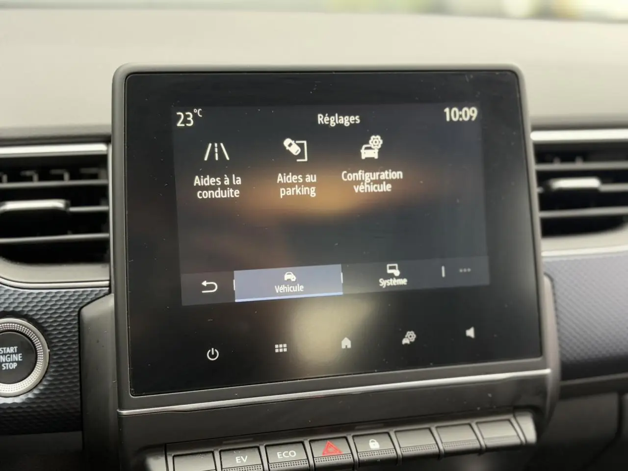 Écran tactile central du tableau de bord du Renault Arkana E-Tech 2024 affichant les réglages d’aides à la conduite et parking.