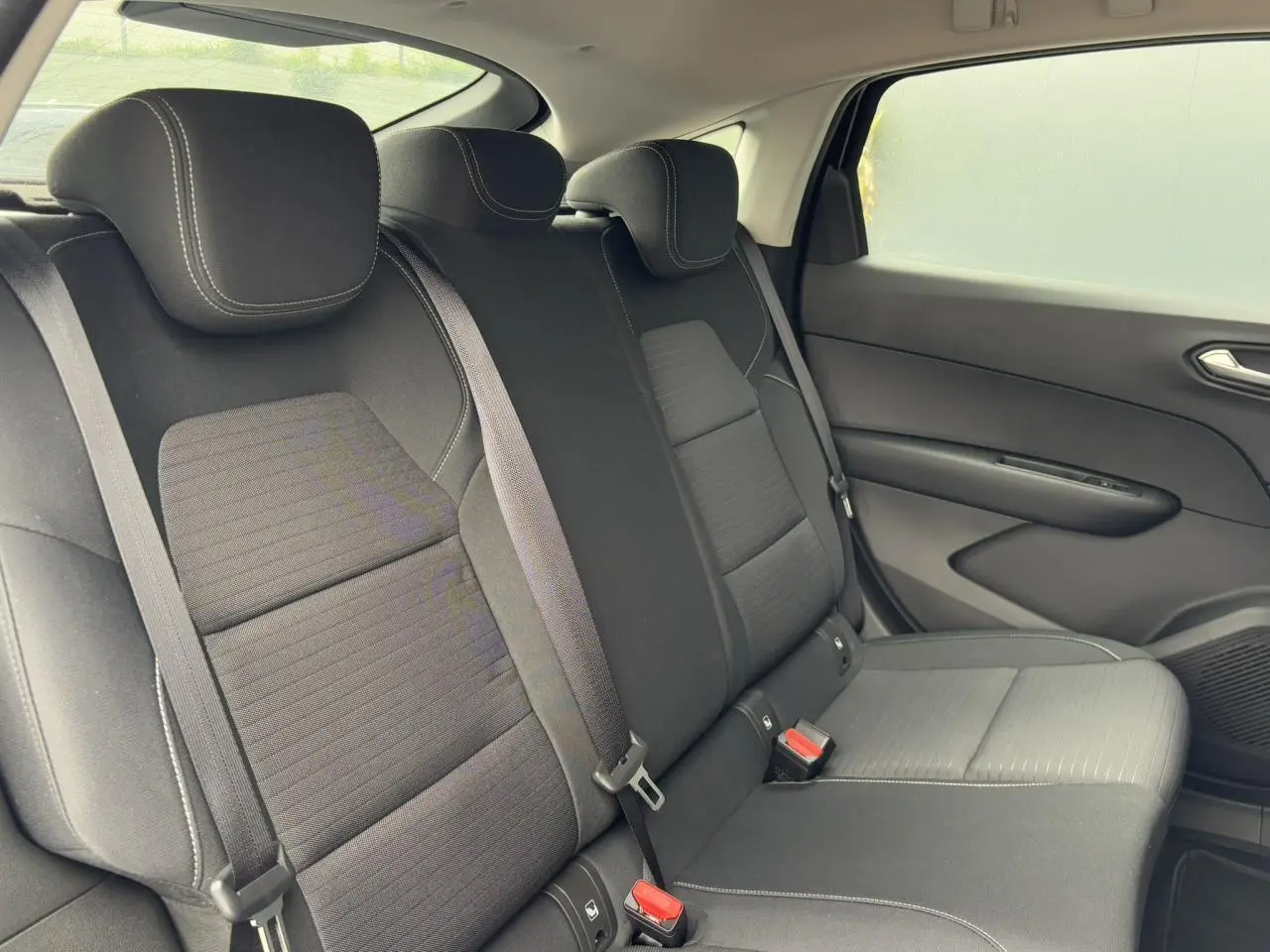 Vue latérale droite des sièges arrière noirs du Renault Arkana E-Tech Full Hybrid 145 Evolution 2024, tissu avec surpiqûres contrastées.