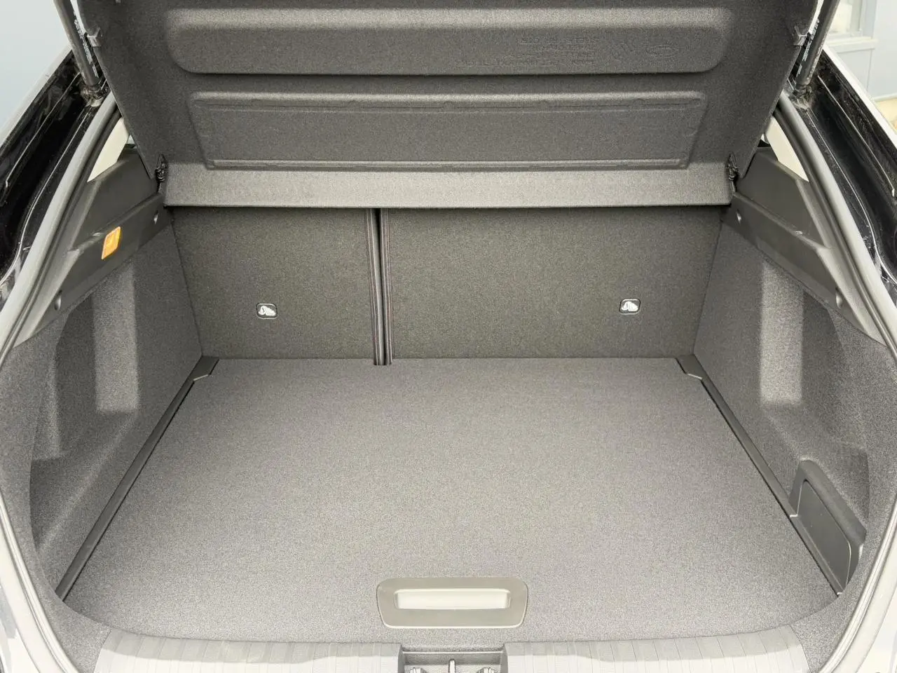 Coffre ouvert du Renault Arkana noir métal 2024, vue arrière montrant un espace de rangement spacieux et propre.