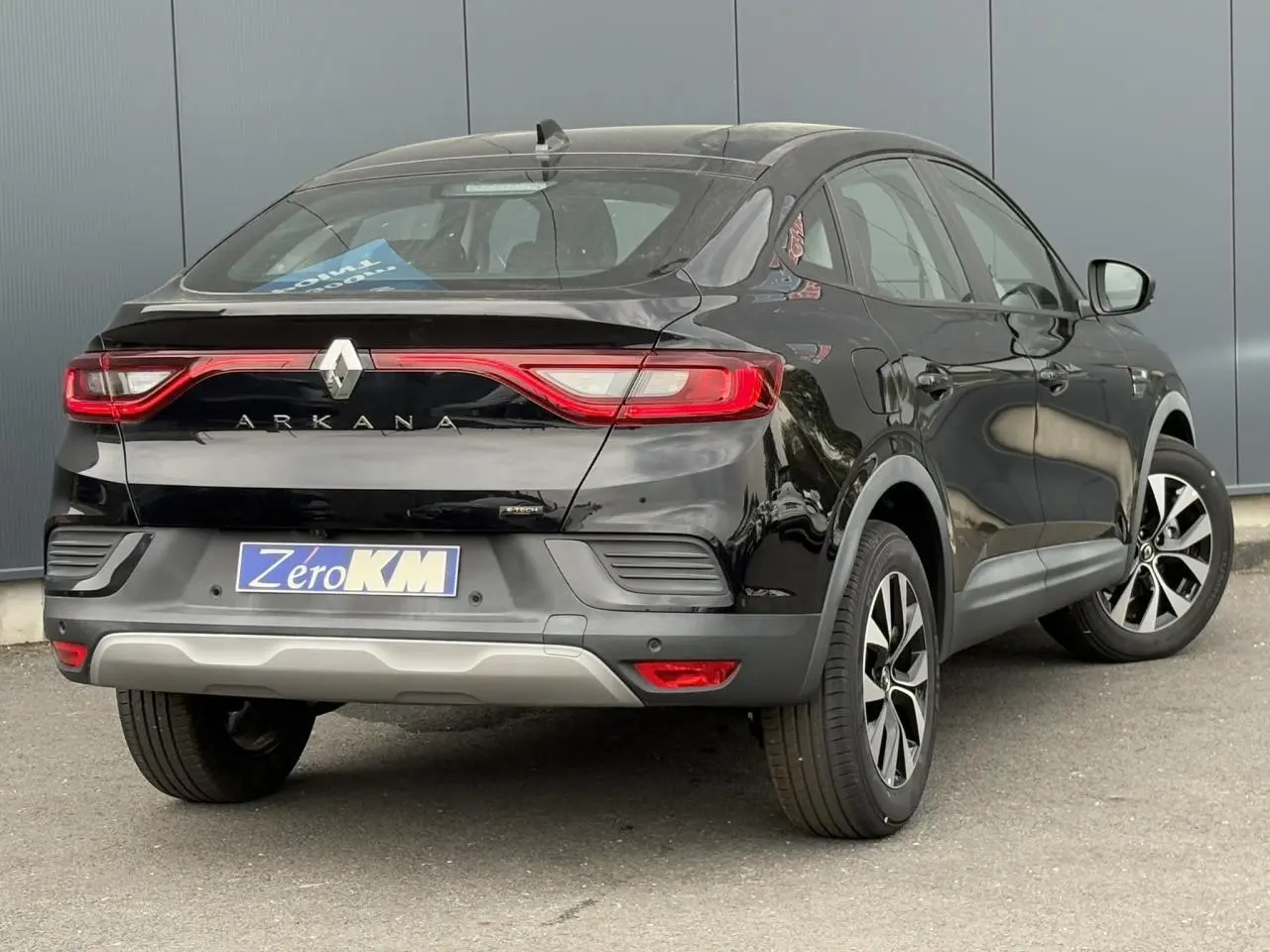 Vue 3/4 arrière droite du Renault Arkana E-Tech Full Hybrid 145 noir métal avec jantes alliage et feux LED distinctifs.