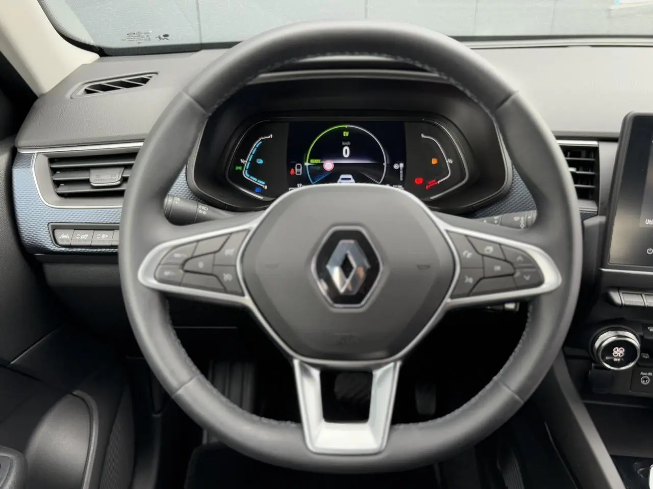 Vue rapprochée du volant Renault Arkana E-Tech 2024 avec tableau de bord numérique et commandes intégrées.