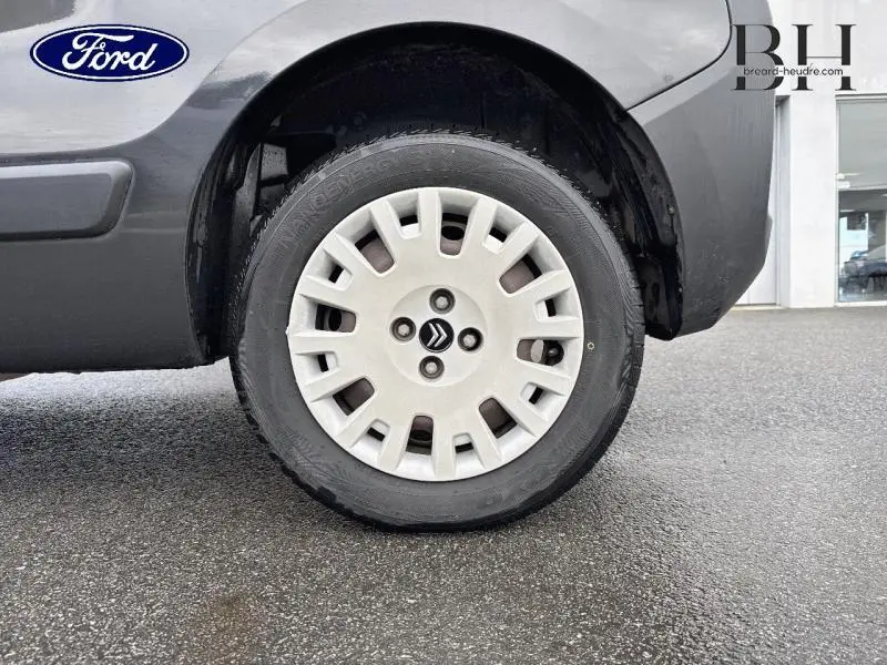 Gros plan sur la roue avant droite grise Graphito d'une Citroën Nemo 1.4i Confort 5 portes, avec enjoliveur blanc et logo Citroën.