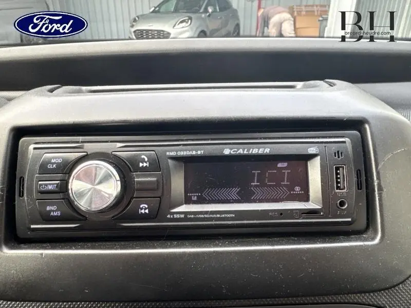 Vue rapprochée de l'autoradio Caliber noir dans un Citroën Nemo gris Graphito, tableau de bord visible en arrière-plan.