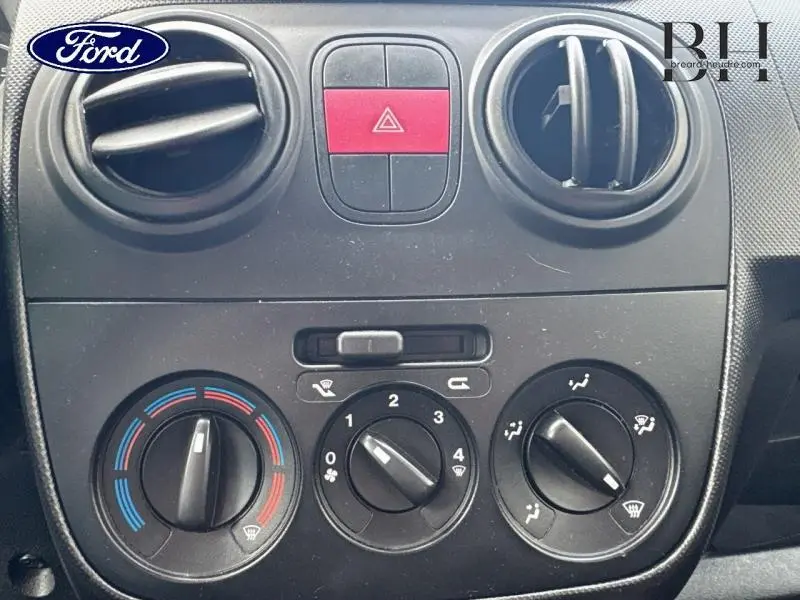 Détail de la console centrale avec commandes de climatisation et bouton de warning sur Citroën Nemo gris Graphito 2013.