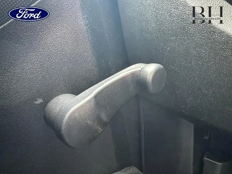 Gros plan sur la manivelle de vitre manuelle intérieure d'une Citroën Nemo gris Graphito, vue côté gauche.