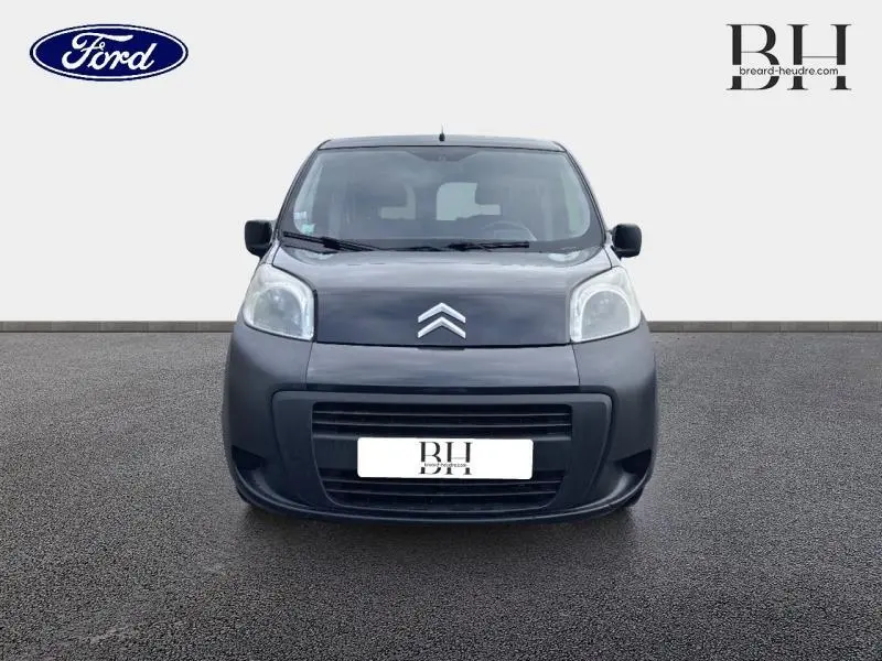 Vue frontale d'une Citroën Nemo 1.4i Confort gris Graphito avec phares arrondis et calandre noire.