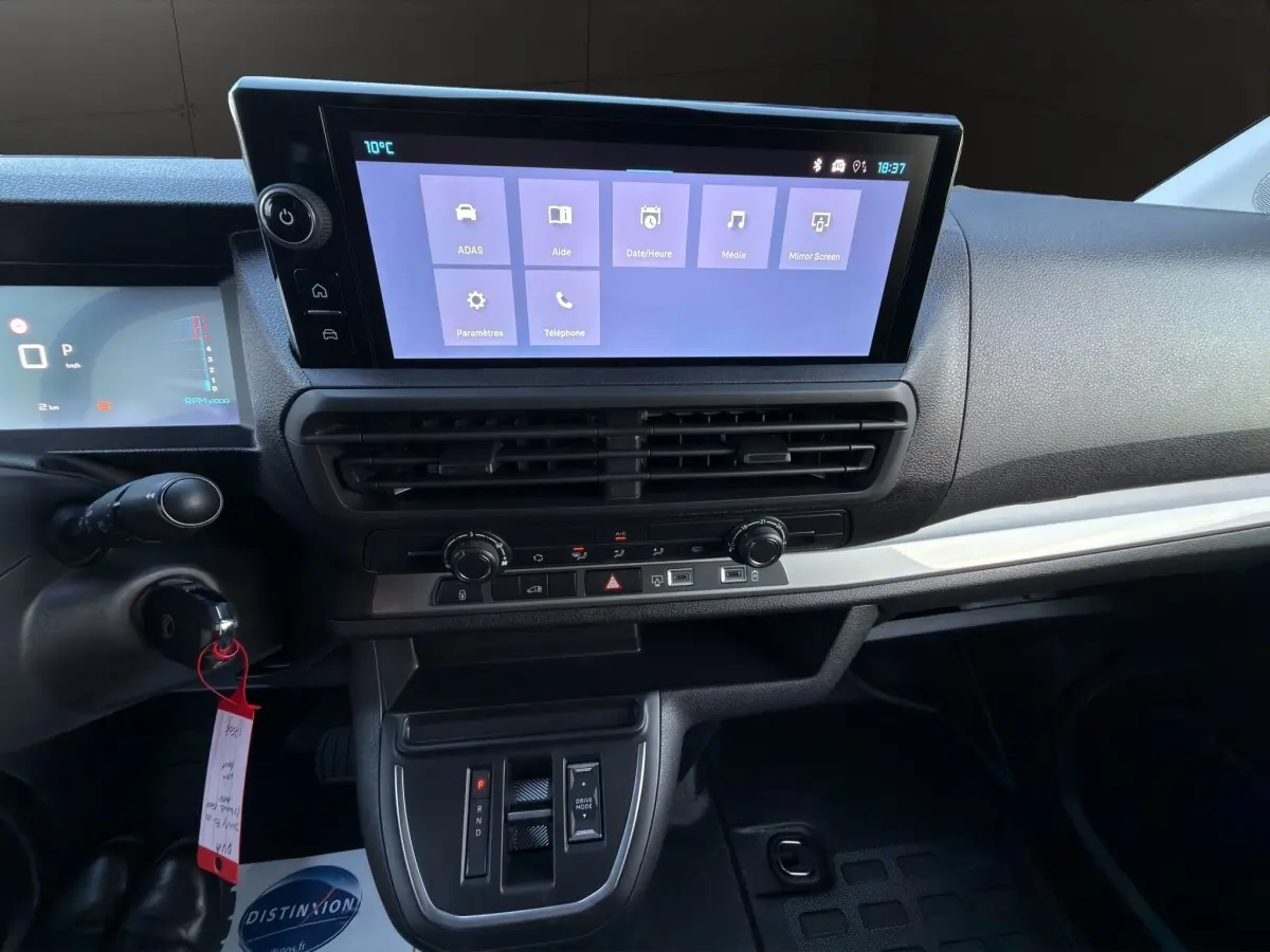 Tableau de bord central et écran tactile du Citroën Jumpy noir, vue intérieure frontale sur la console et commandes.