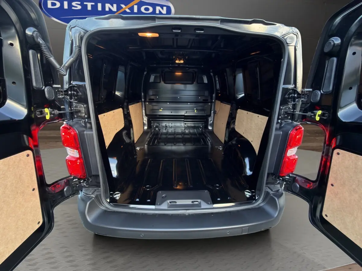 Vue arrière du Citroën Jumpy noir 2026 avec portes ouvertes montrant l'espace de chargement vide et les panneaux latéraux en bois.