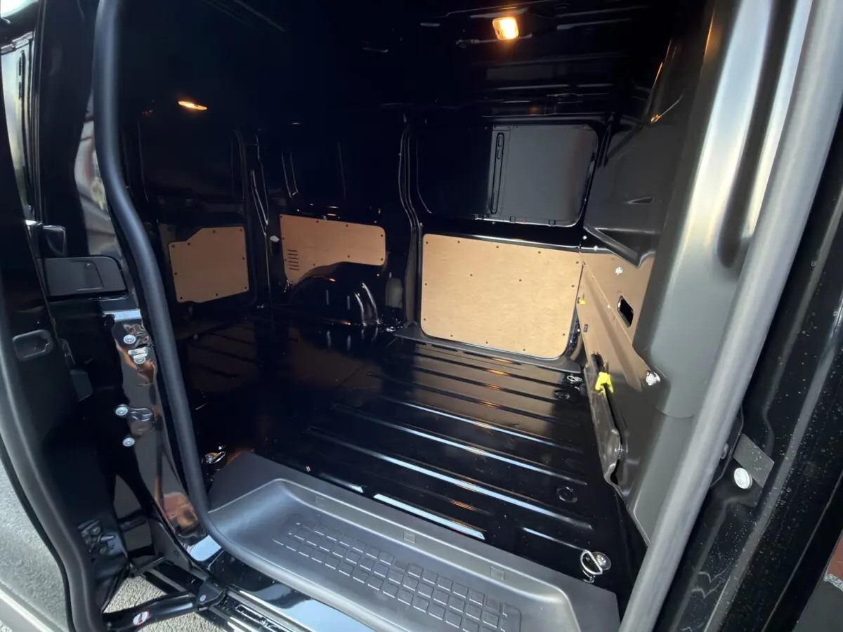 Vue intérieure arrière droite du Citroën Jumpy noir 2026 montrant l’espace de chargement avec cloison pleine.