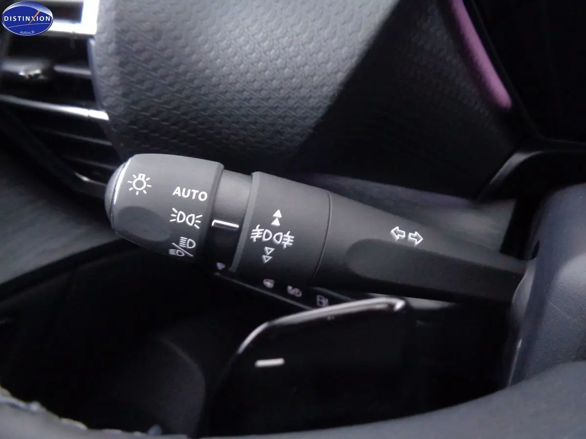 Gros plan sur la commande des phares et clignotants du Citroën C5 X 1.6 Hybrid 225 Shine noir métal, intérieur sombre.