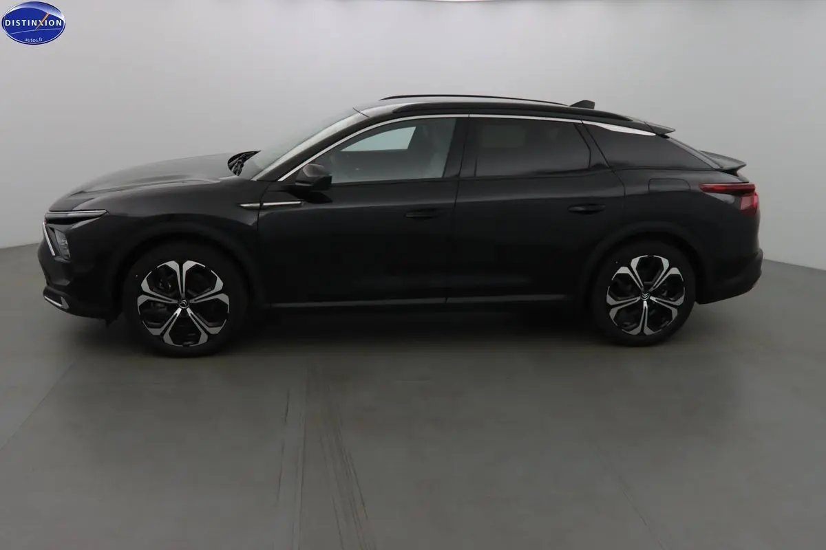 Profil côté gauche d'une Citroën C5 X hybride rechargeable noire métal, avec jantes bi-ton et toit panoramique.