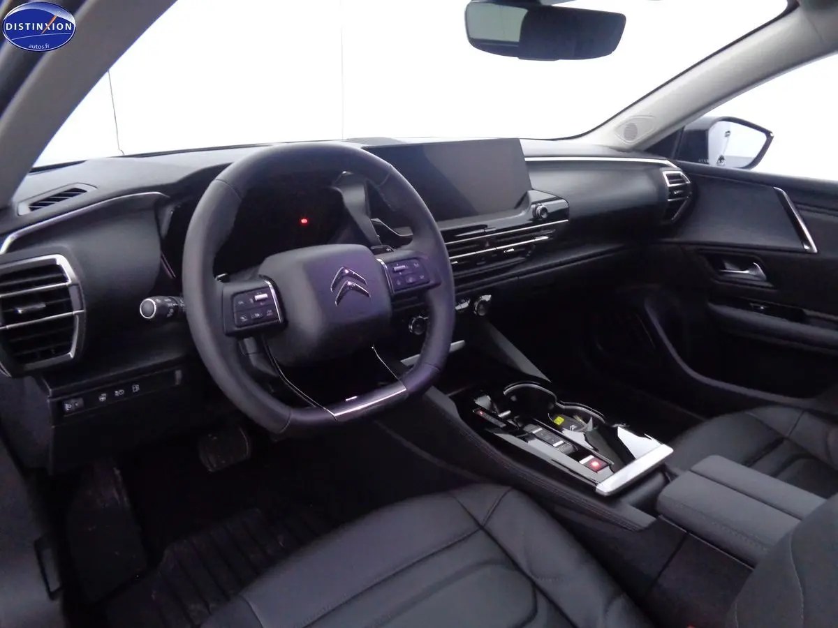Intérieur noir du Citroën C5 X 1.6 Hybrid 225 Shine vu côté conducteur, avec tableau de bord moderne et écran tactile.