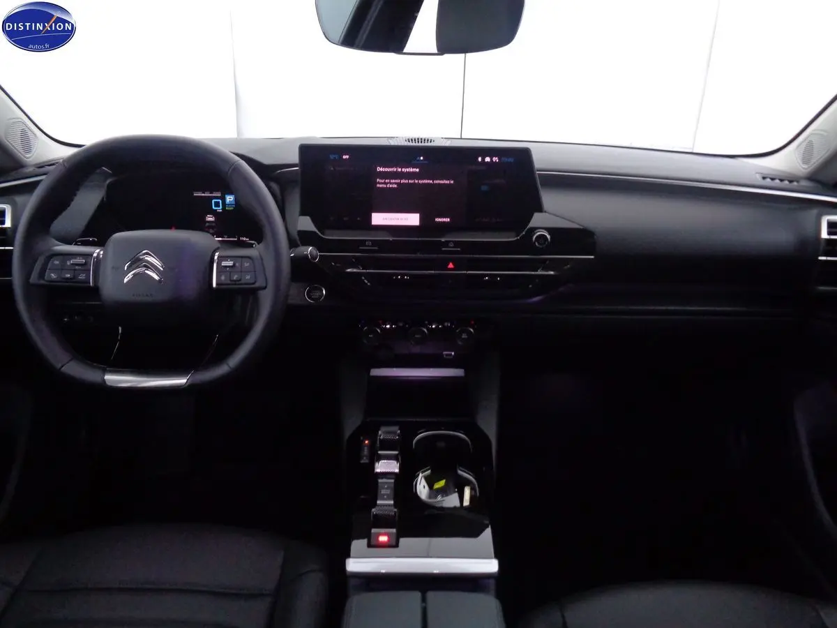 Intérieur noir du Citroën C5 X 1.6 Hybrid 225 Shine, vue frontale sur le tableau de bord et le volant multifonction.