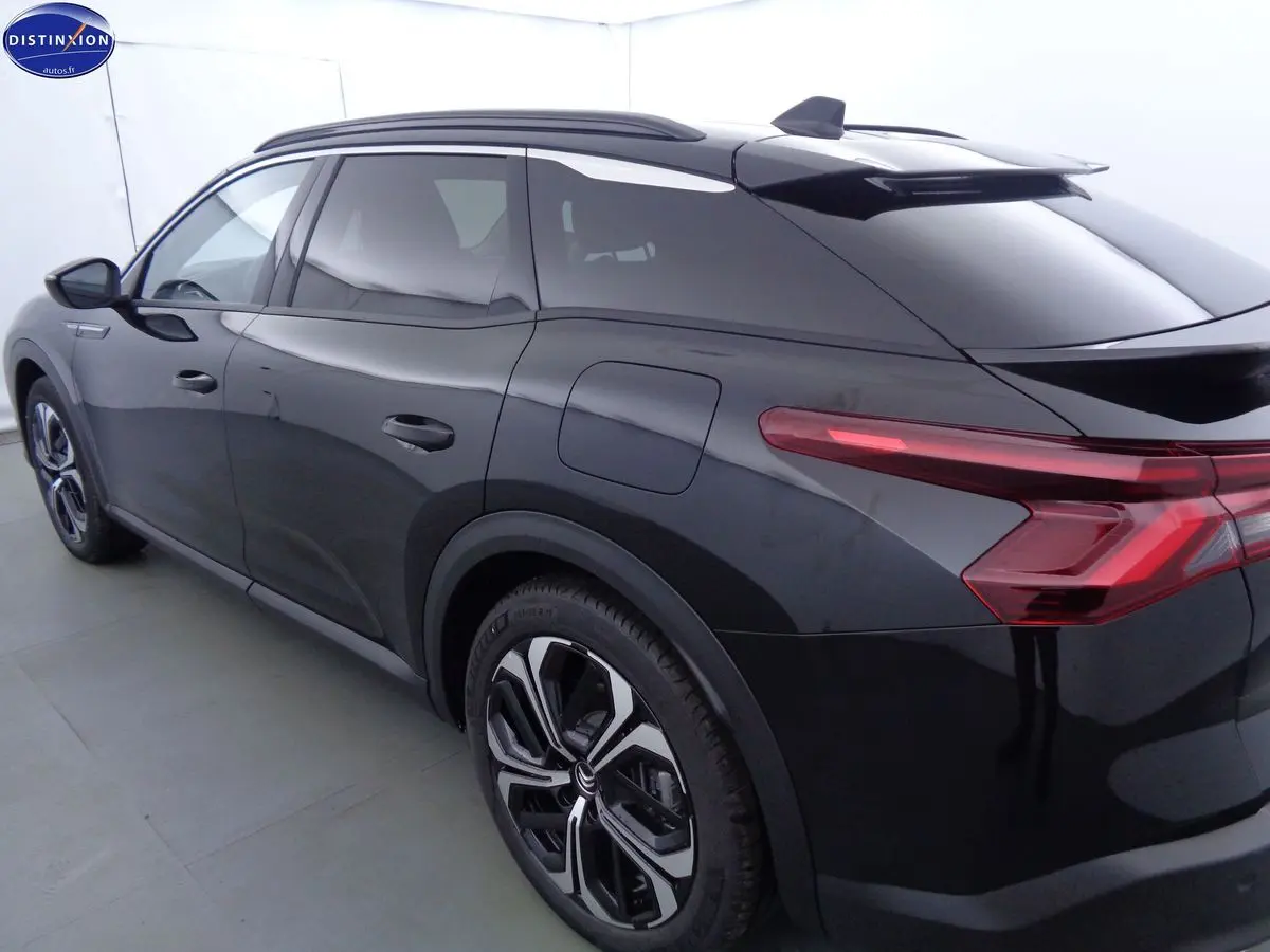 Vue 3/4 arrière côté gauche d'une Citroën C5 X noire métal avec feux arrière LED et jantes bi-ton.