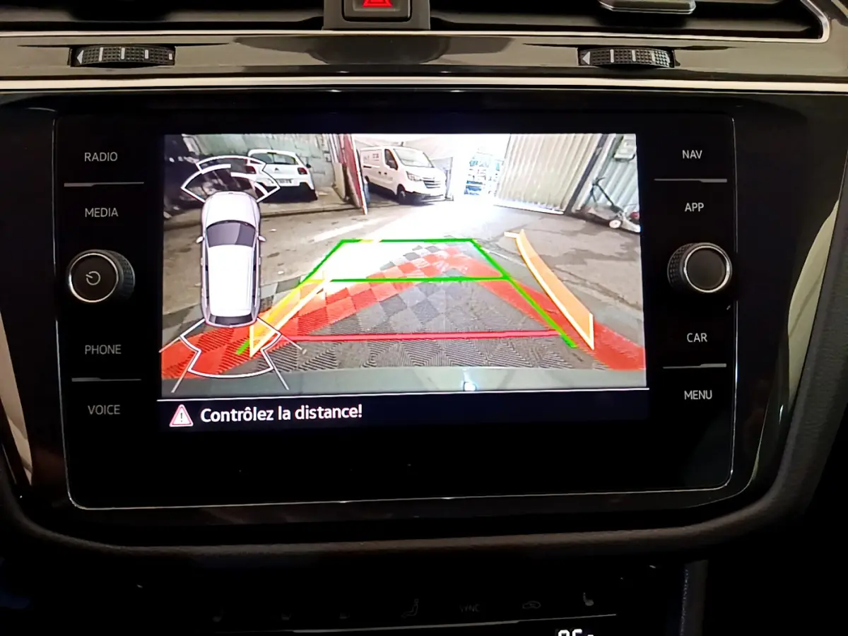 Écran tactile intérieur du Volkswagen Tiguan 2021 montrant la caméra de recul avec alertes de distance en mode stationnement.