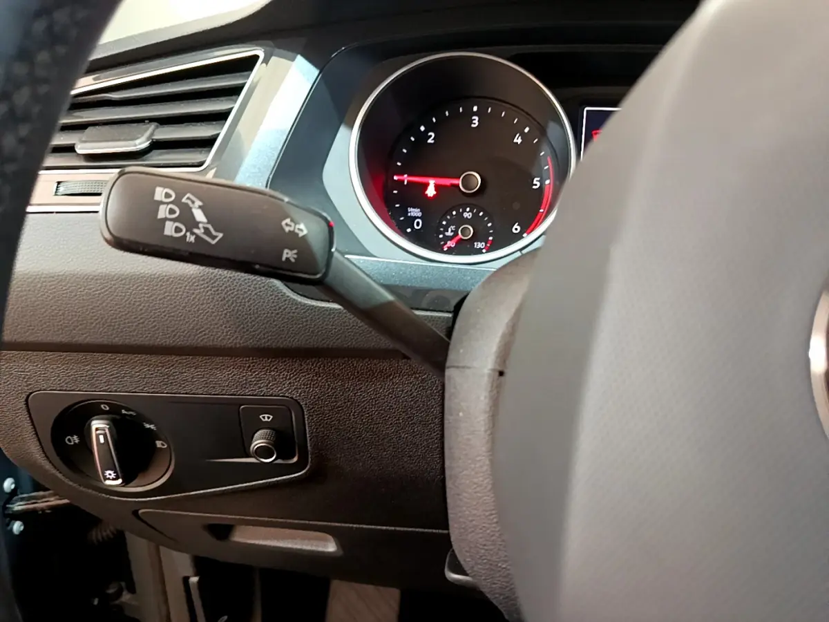 Gros plan sur le tableau de bord et le commodo gauche du Volkswagen Tiguan gris clair, avec compte-tours visible.