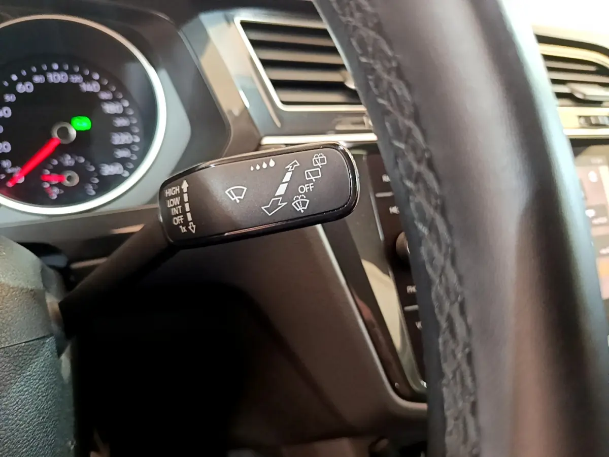 Gros plan sur la commande d’essuie-glace noire côté gauche du volant cuir du Volkswagen Tiguan gris clair 2021.