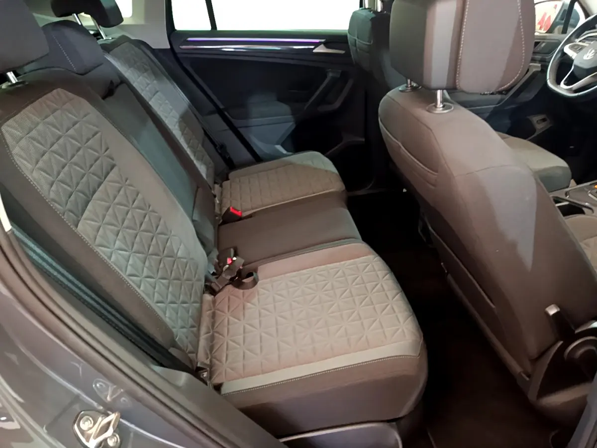 Vue intérieure côté gauche montrant la banquette arrière grise à motifs géométriques du Volkswagen Tiguan 2021.