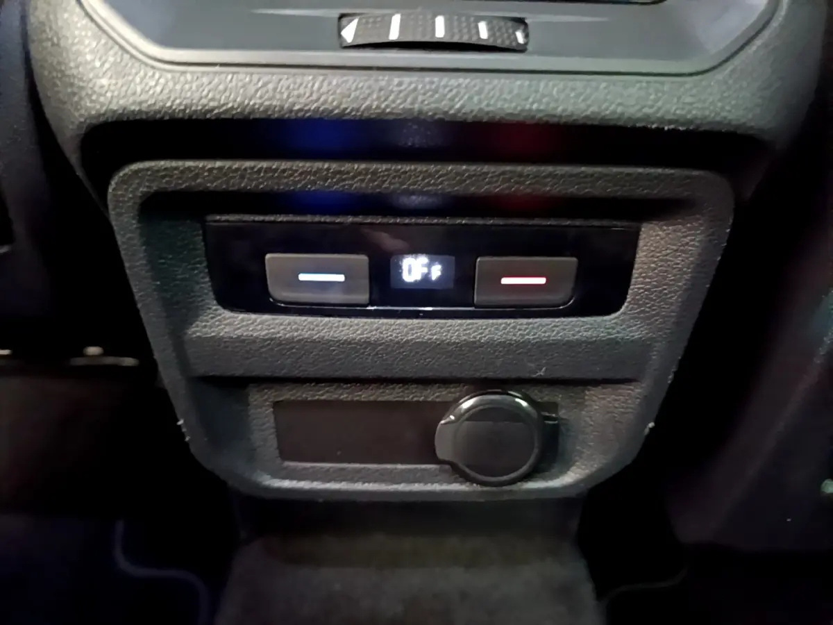 Vue rapprochée du panneau de commande de climatisation arrière noir avec affichage digital dans un Volkswagen Tiguan gris clair.