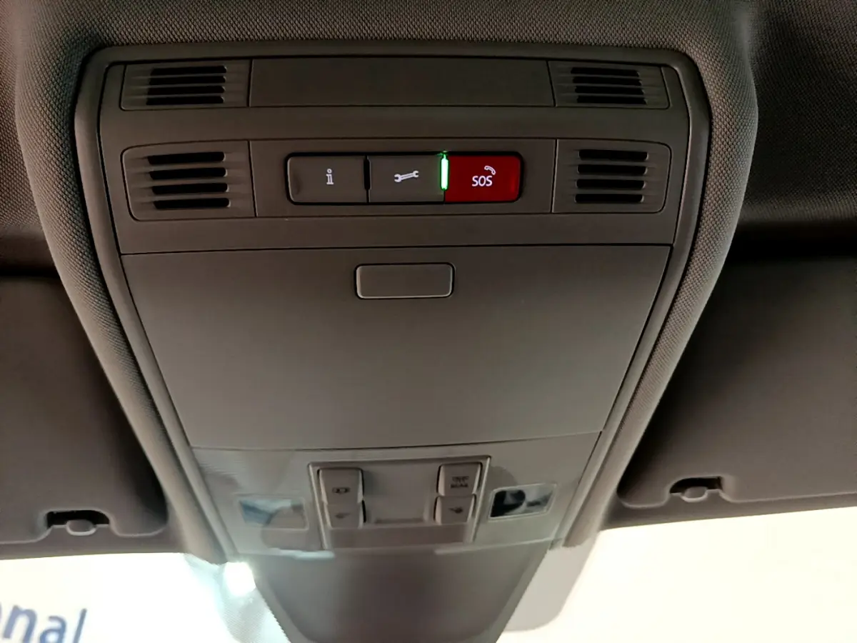 Vue en contre-plongée du panneau de commandes au plafond intérieur gris du Volkswagen Tiguan 2021 avec bouton SOS rouge allumé.