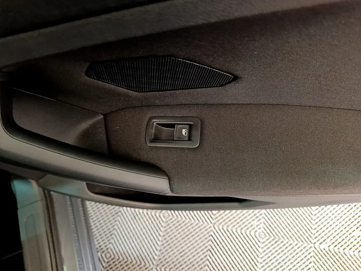 Détail de la poignée intérieure de porte arrière droite du Volkswagen Tiguan gris clair 2021.