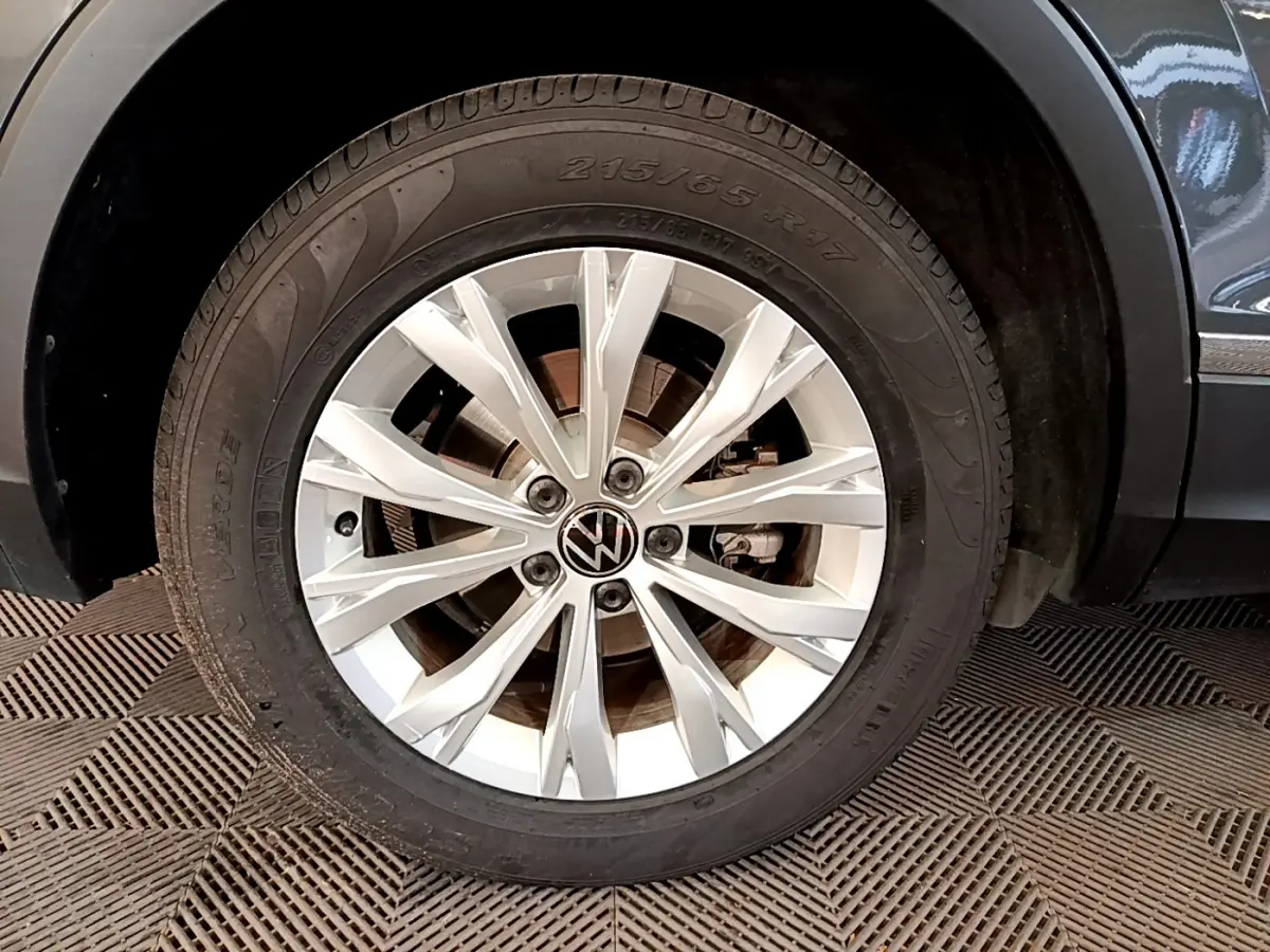 Gros plan sur la roue avant droite gris clair du Volkswagen Tiguan 2.0 TDI avec jante alliage à 10 branches.