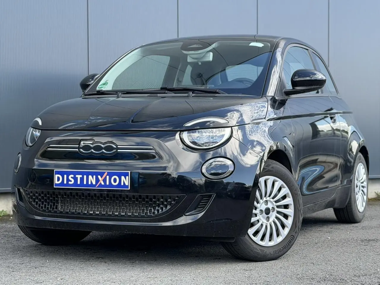 Vue 3/4 avant droit d'une FIAT 500 électrique 2024 en peinture Noir Onyx avec jantes alu 16 pouces.