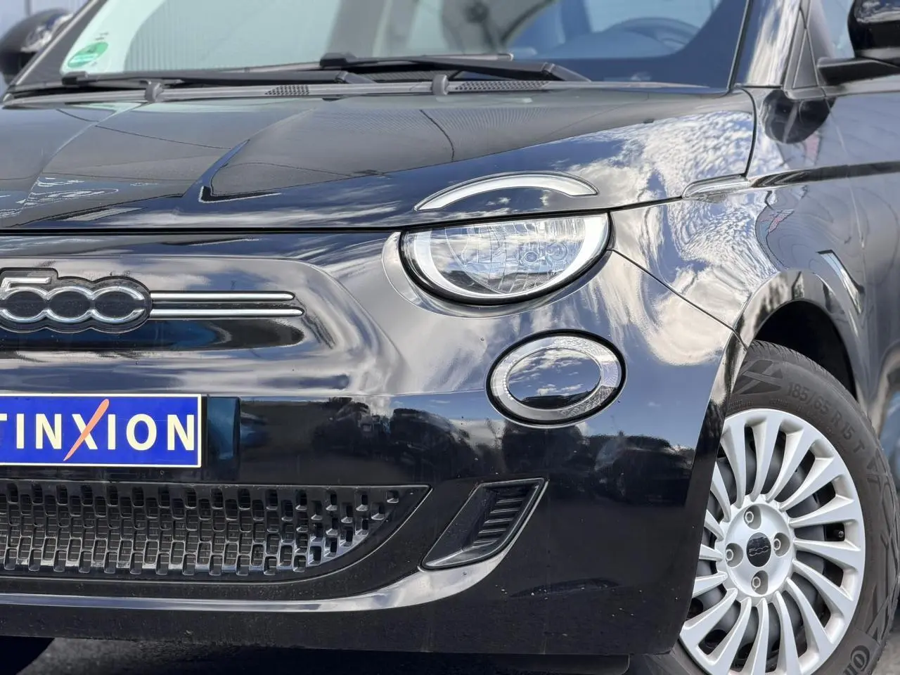 Gros plan sur l'avant droit d'une FIAT 500 électrique noire avec jante alu 16 pouces et phares LED.
