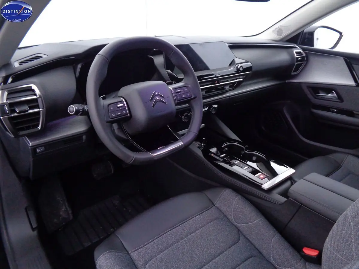 Vue intérieure côté conducteur de la Citroën C5 X 2022 avec tableau de bord noir et volant multifonction.