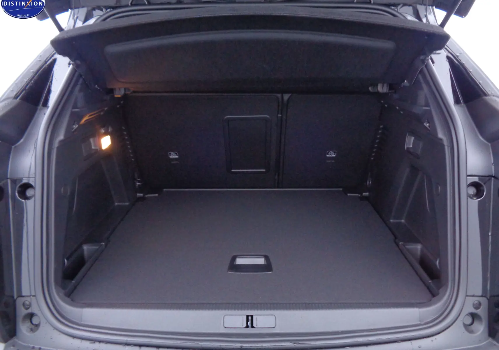Coffre ouvert vu de l'arrière d'un Peugeot 3008 noir perle métal, montrant un espace de chargement propre et spacieux.