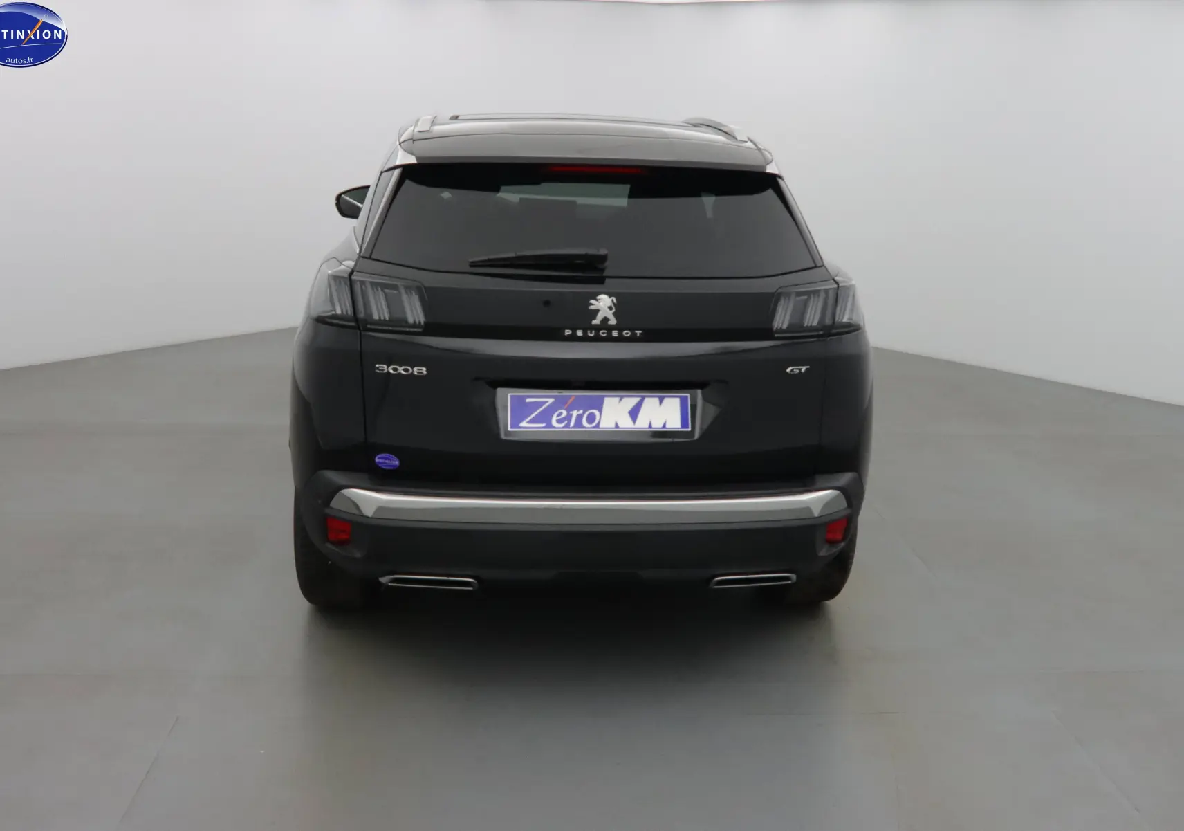 Vue arrière d'un Peugeot 3008 GT noir perle métal avec feux distinctifs et double sortie d'échappement chromée.